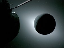 The Moon appears dark in the picture as white sunlight leaks out around its edges. A portion of the Orion spaceship, also in shadow, is visible on the left of the image.